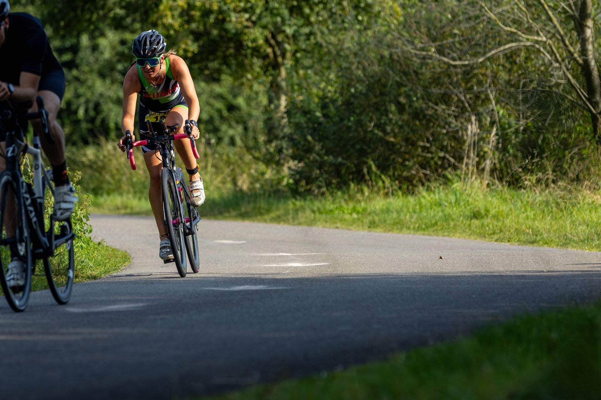 Een man en een vrouw fietsen over een weg.