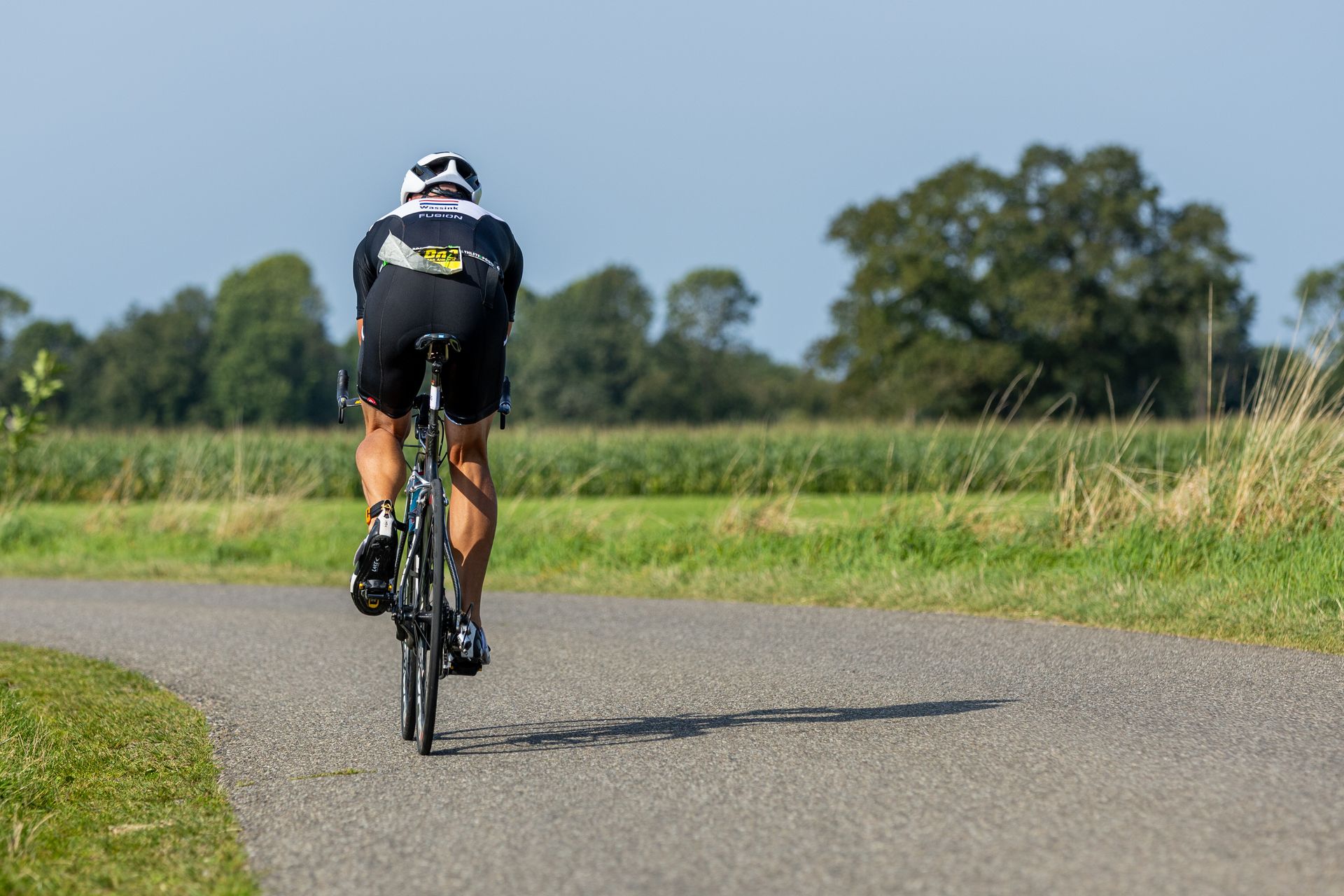 Een man fietst over een landweg.