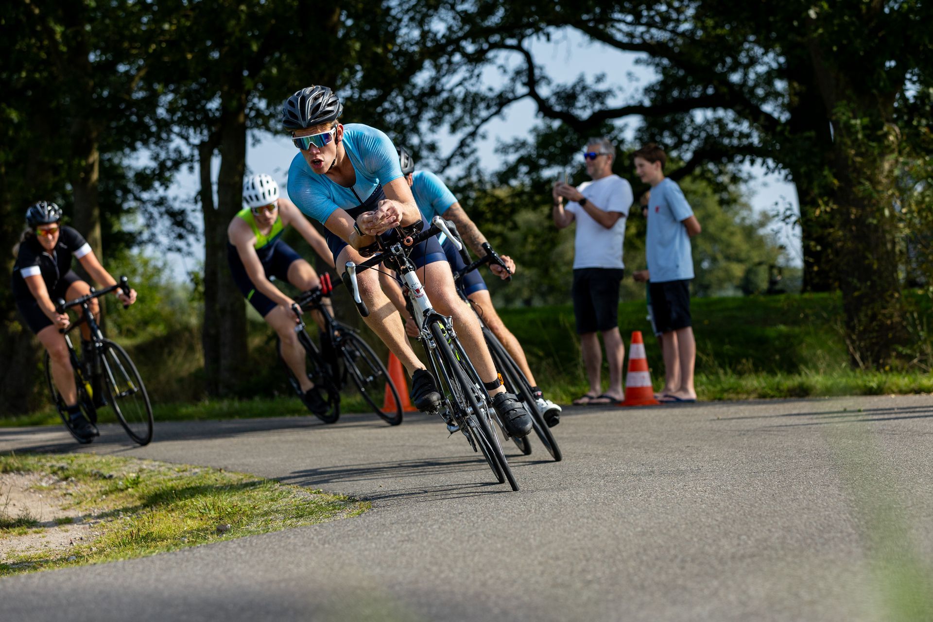 Een groep mensen fietst over een weg.