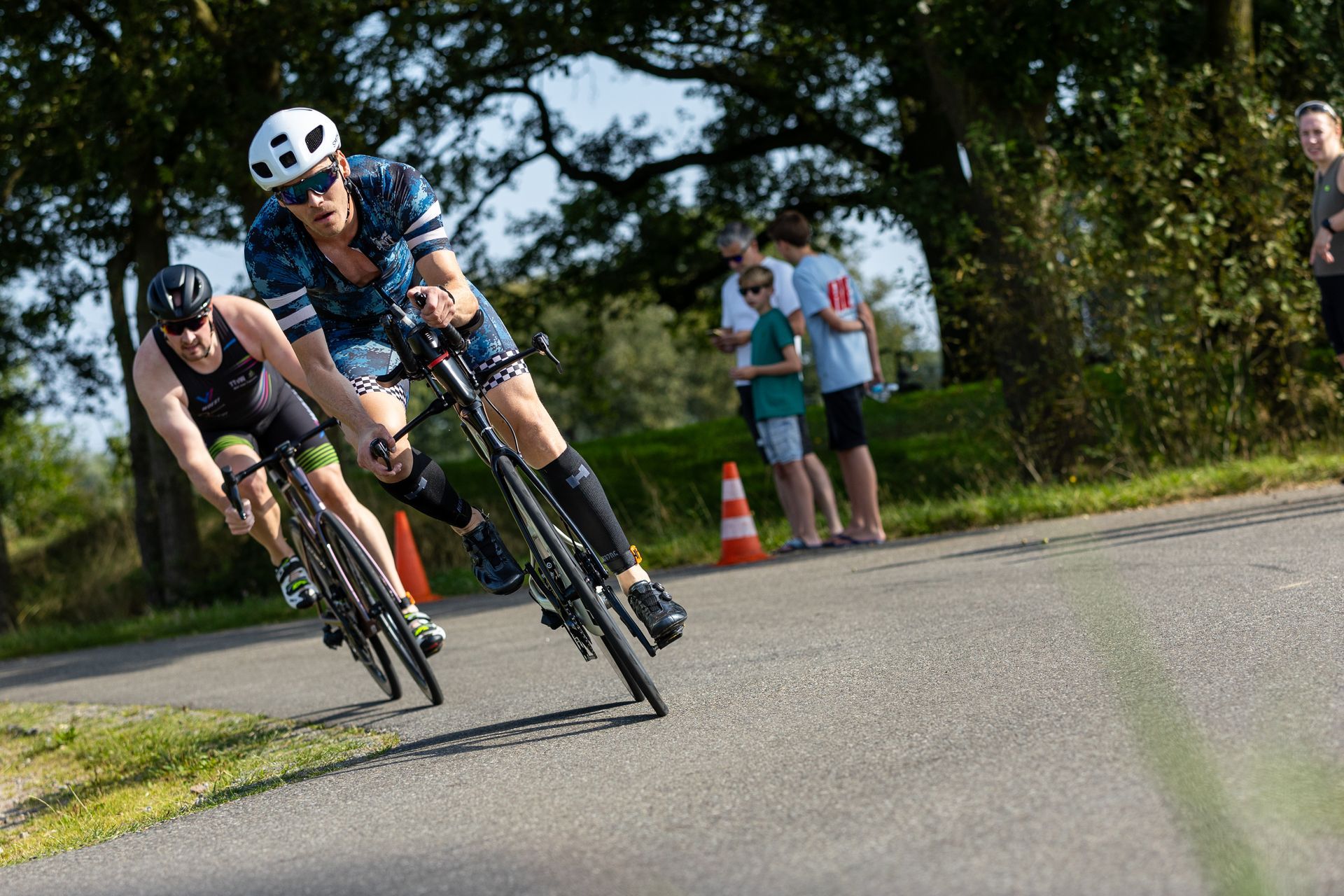 Twee mannen fietsen over een weg.