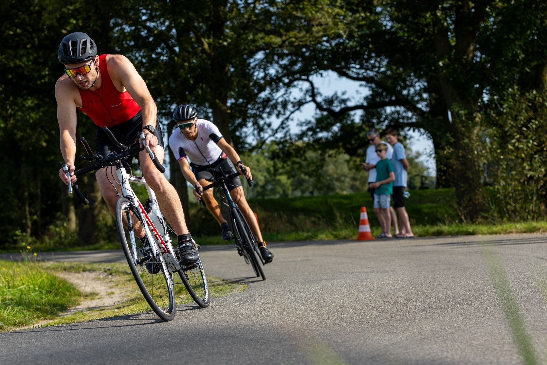 Twee mannen fietsen over een weg.