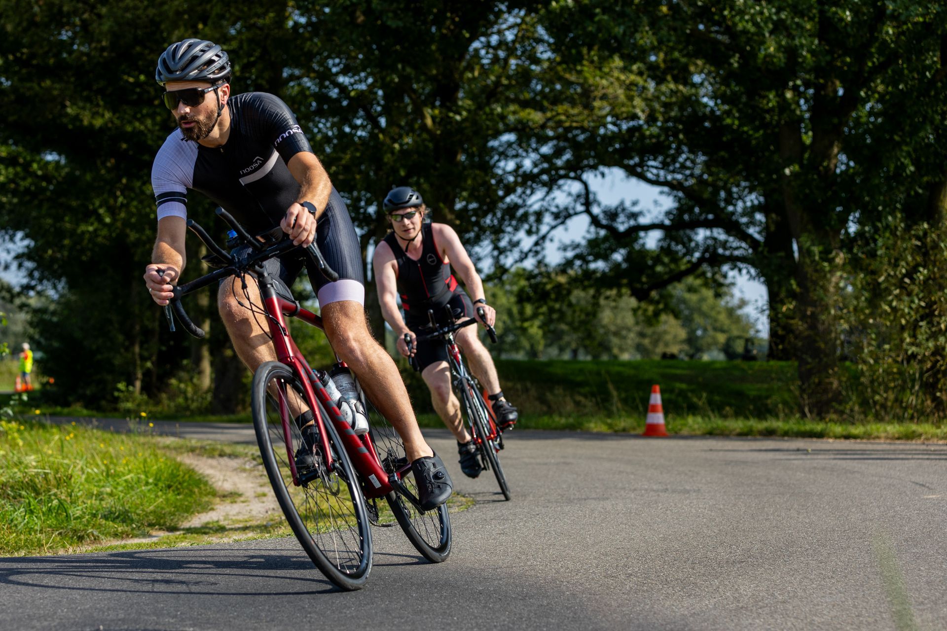 Twee mannen fietsen over een weg.