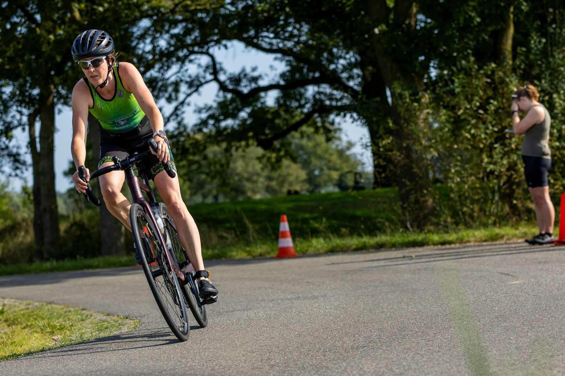 Een vrouw fietst over een weg.