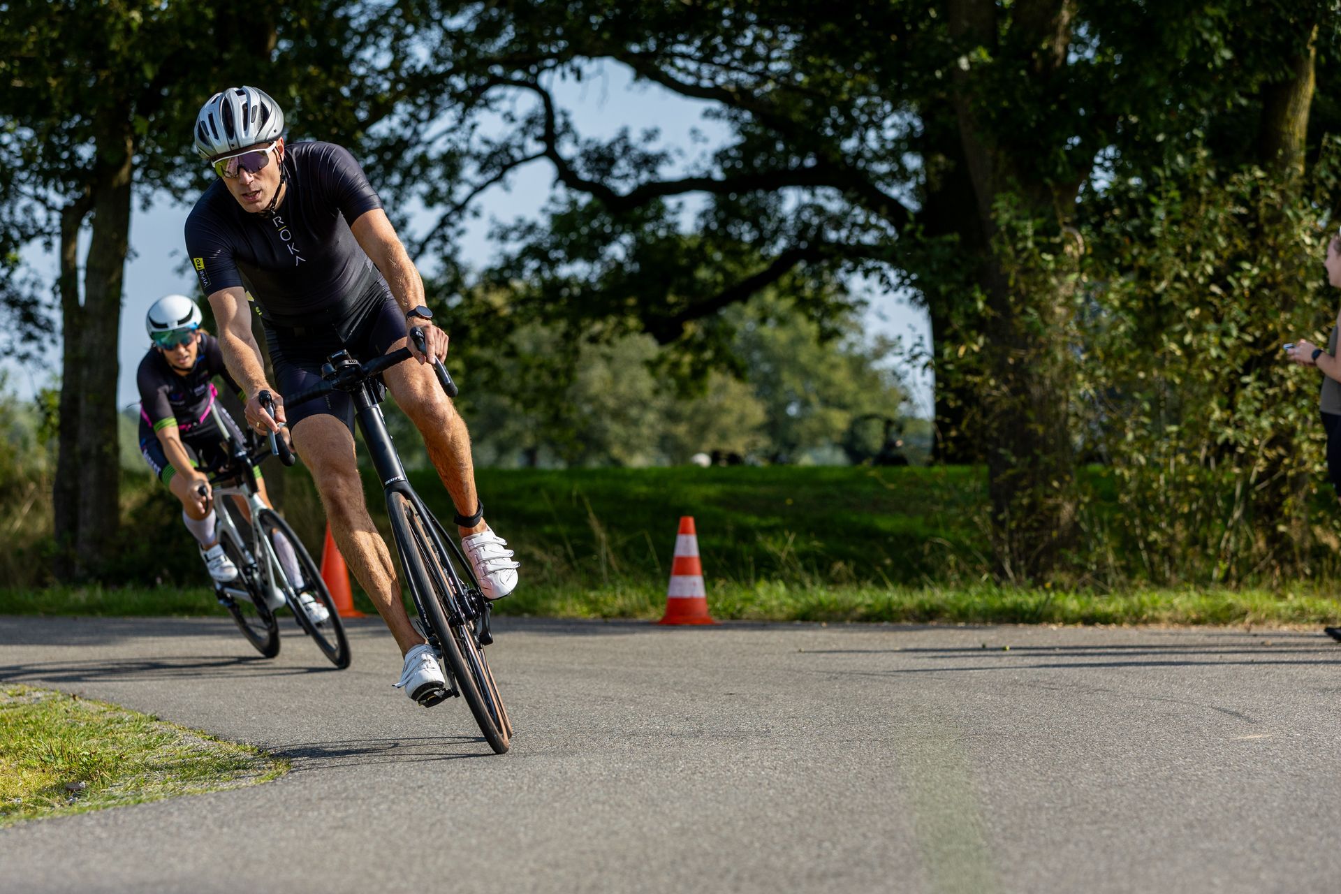Twee mannen fietsen over een weg.