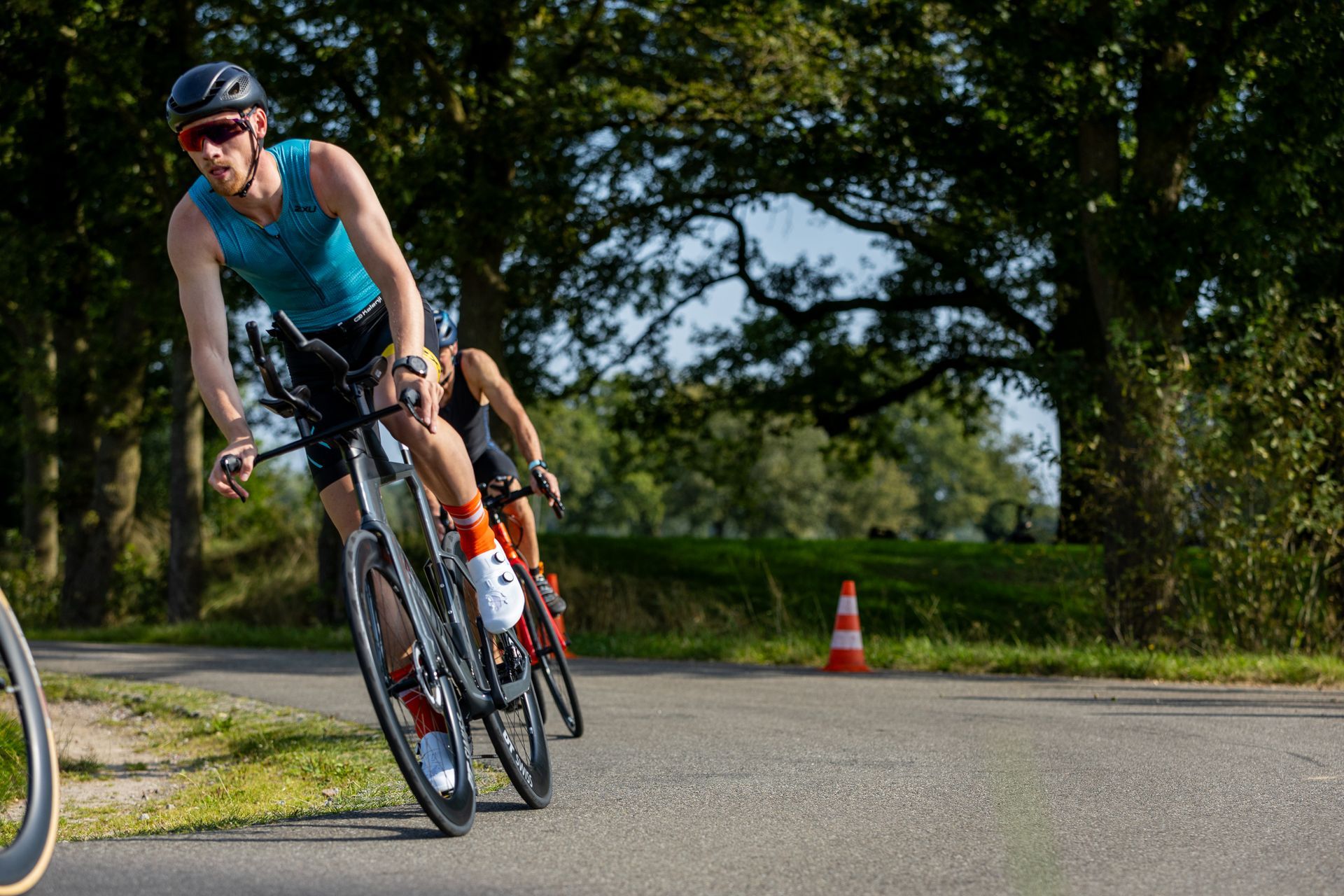 Een man en een vrouw fietsen over een weg.