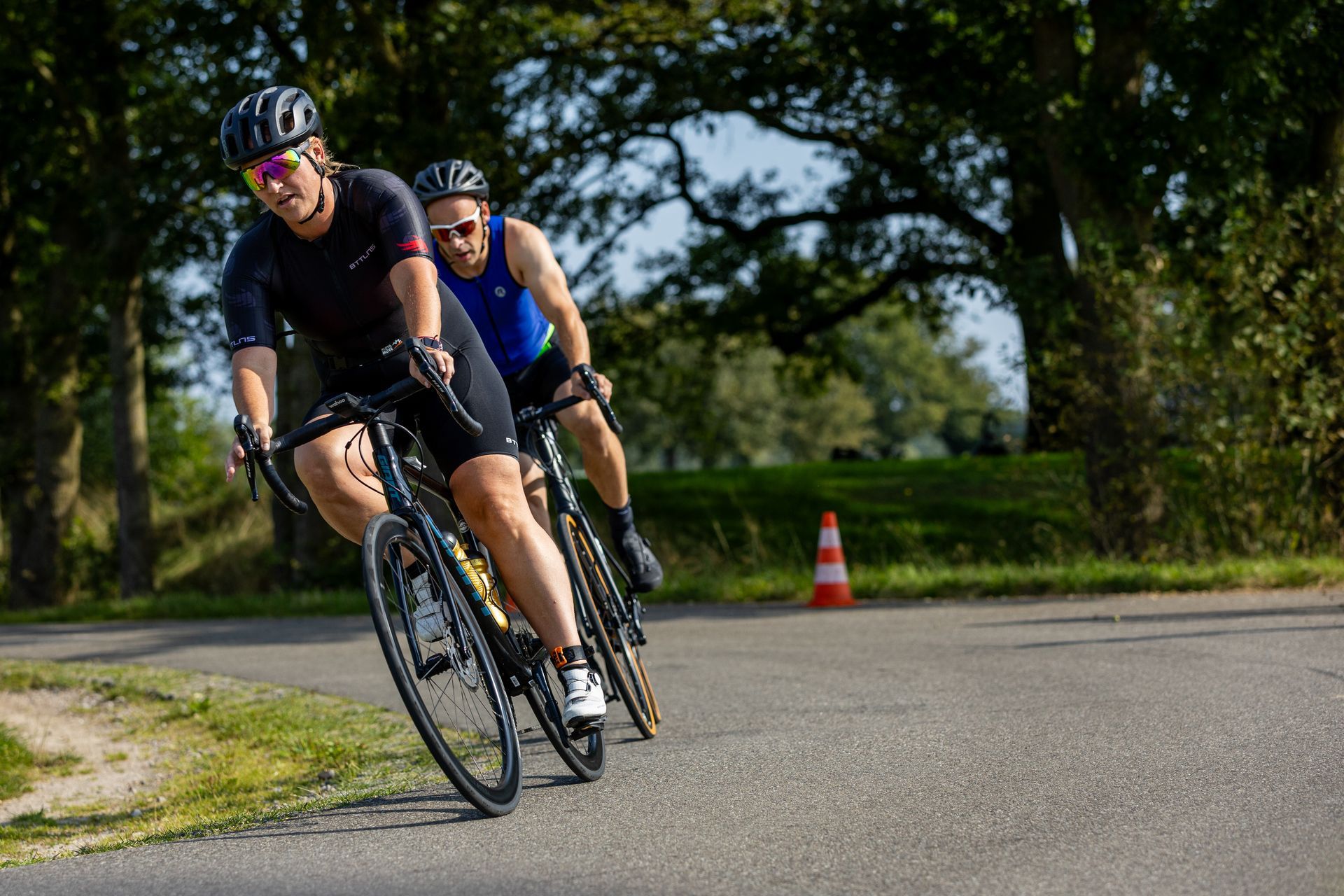 Twee mannen fietsen over een weg.