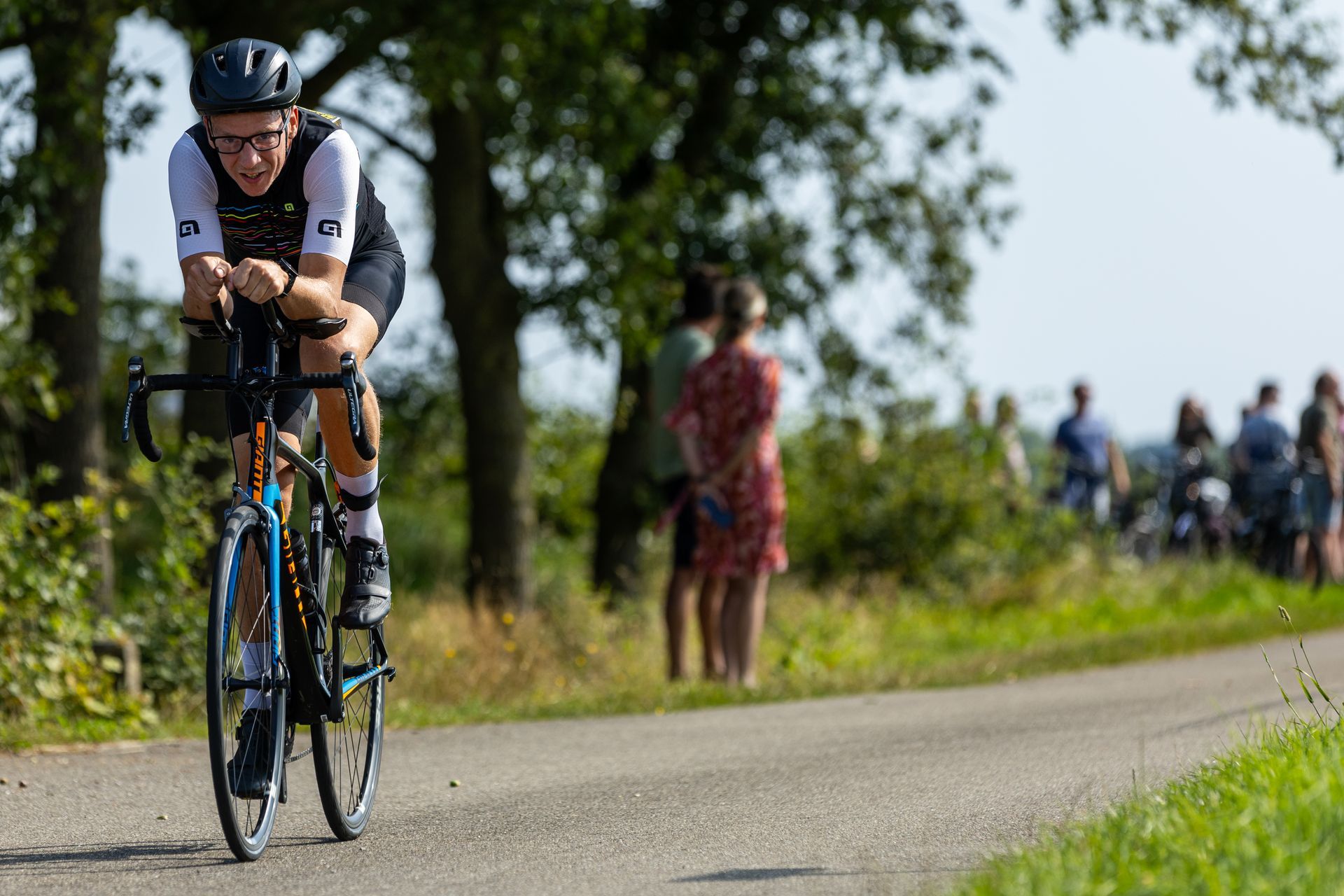 Een man fietst over een landweg.