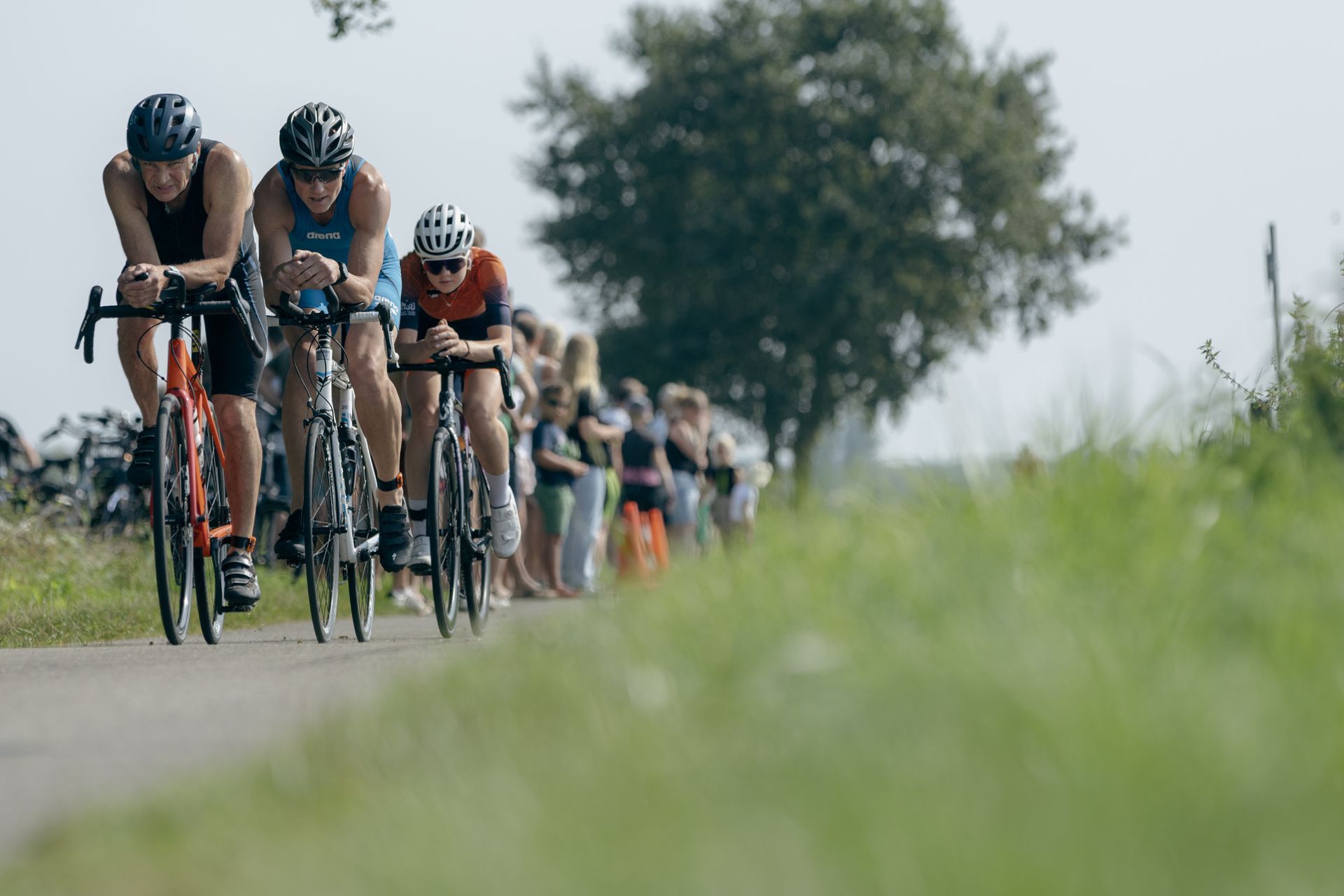 Een groep mensen fietst over een weg.