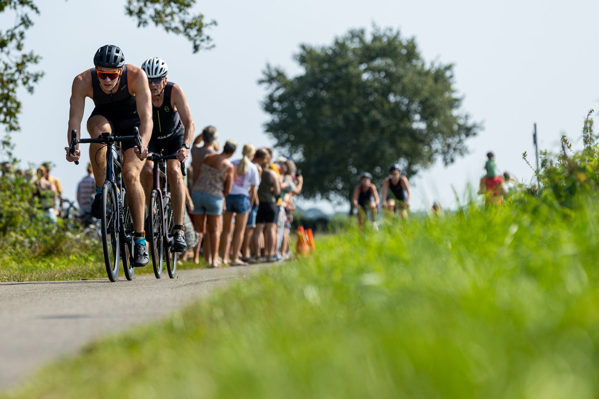 Een groep mensen fietst over een weg.