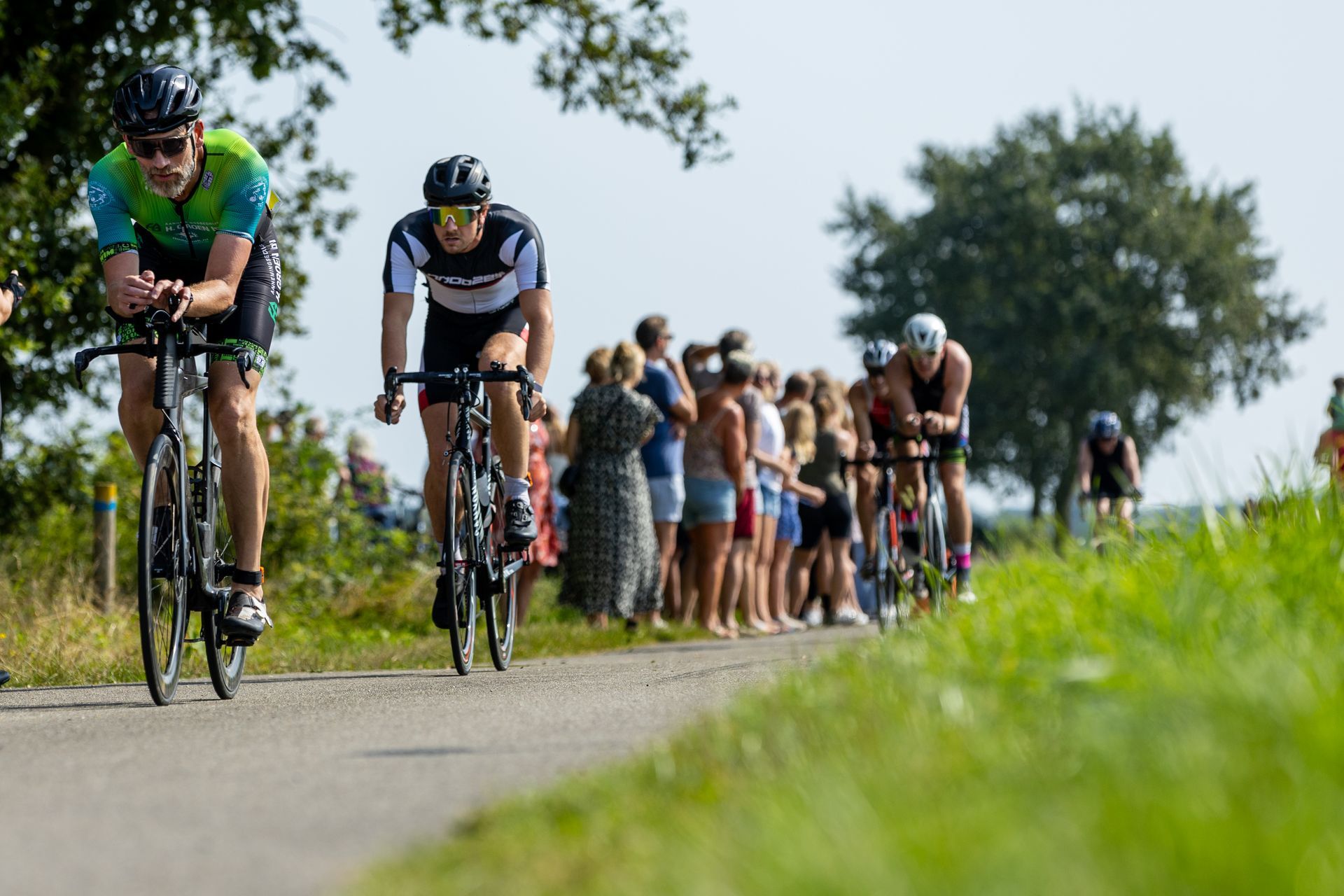 Een groep mensen fietst over een weg.