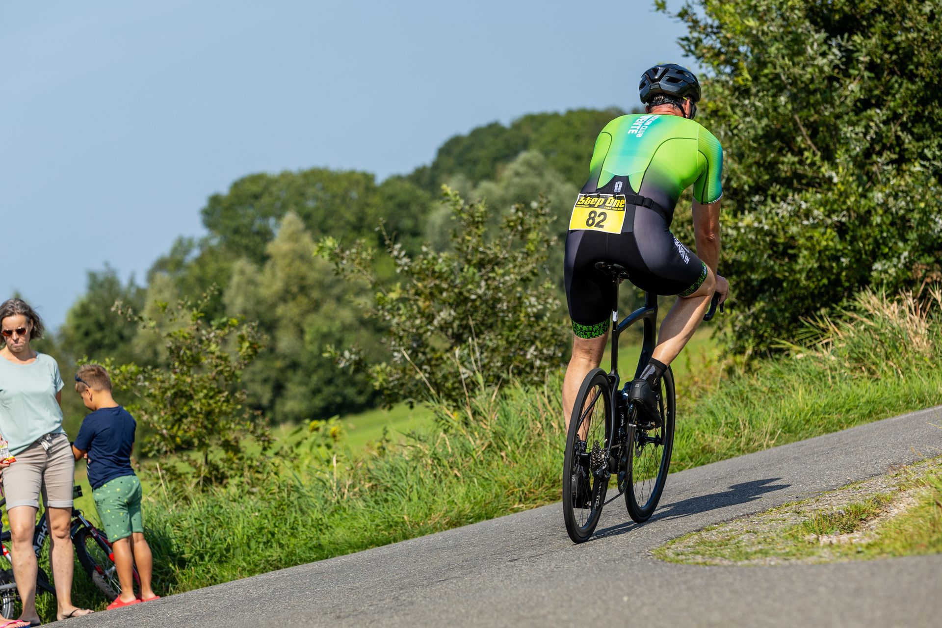 Een man fietst een heuvel af.