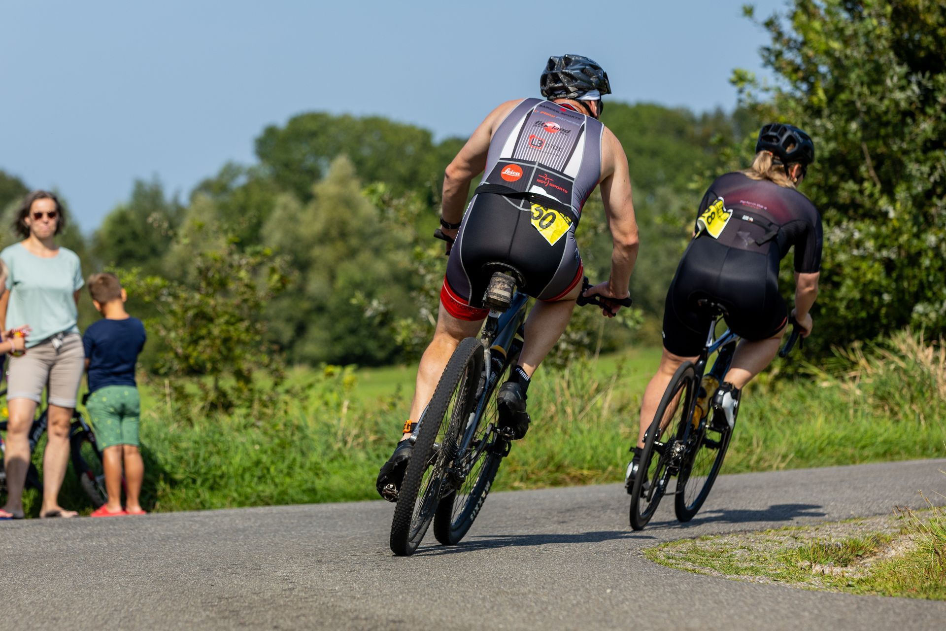 Twee mensen fietsen over een weg.