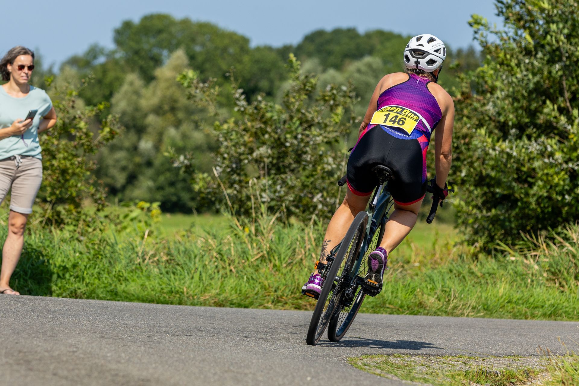 Een vrouw fietst over een weg.