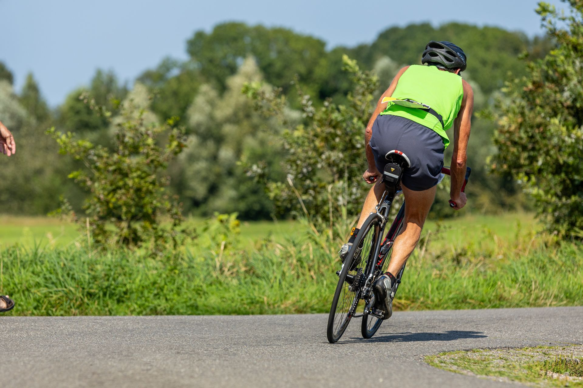Een vrouw fietst over een weg.
