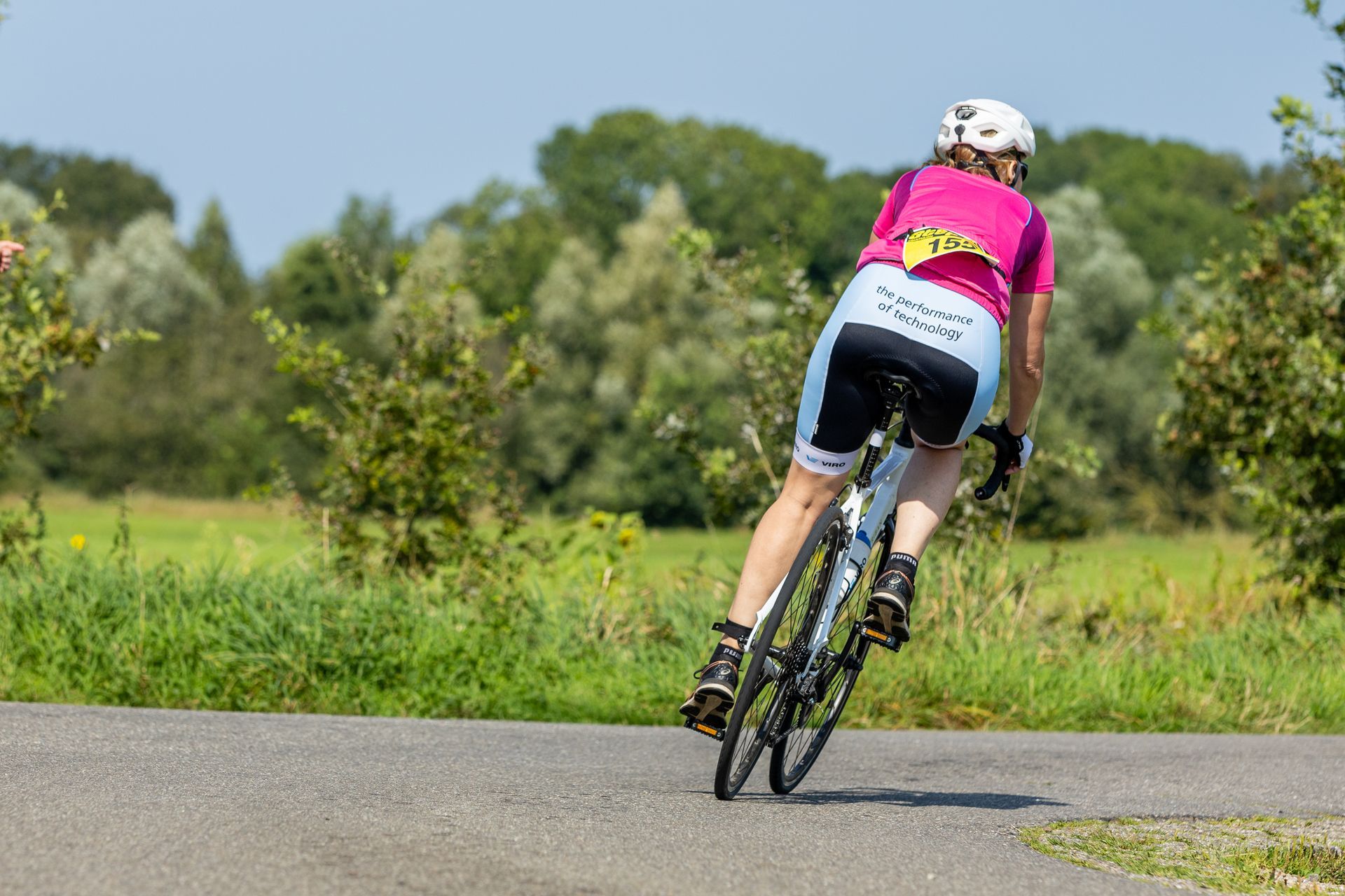 Een vrouw fietst over een weg.