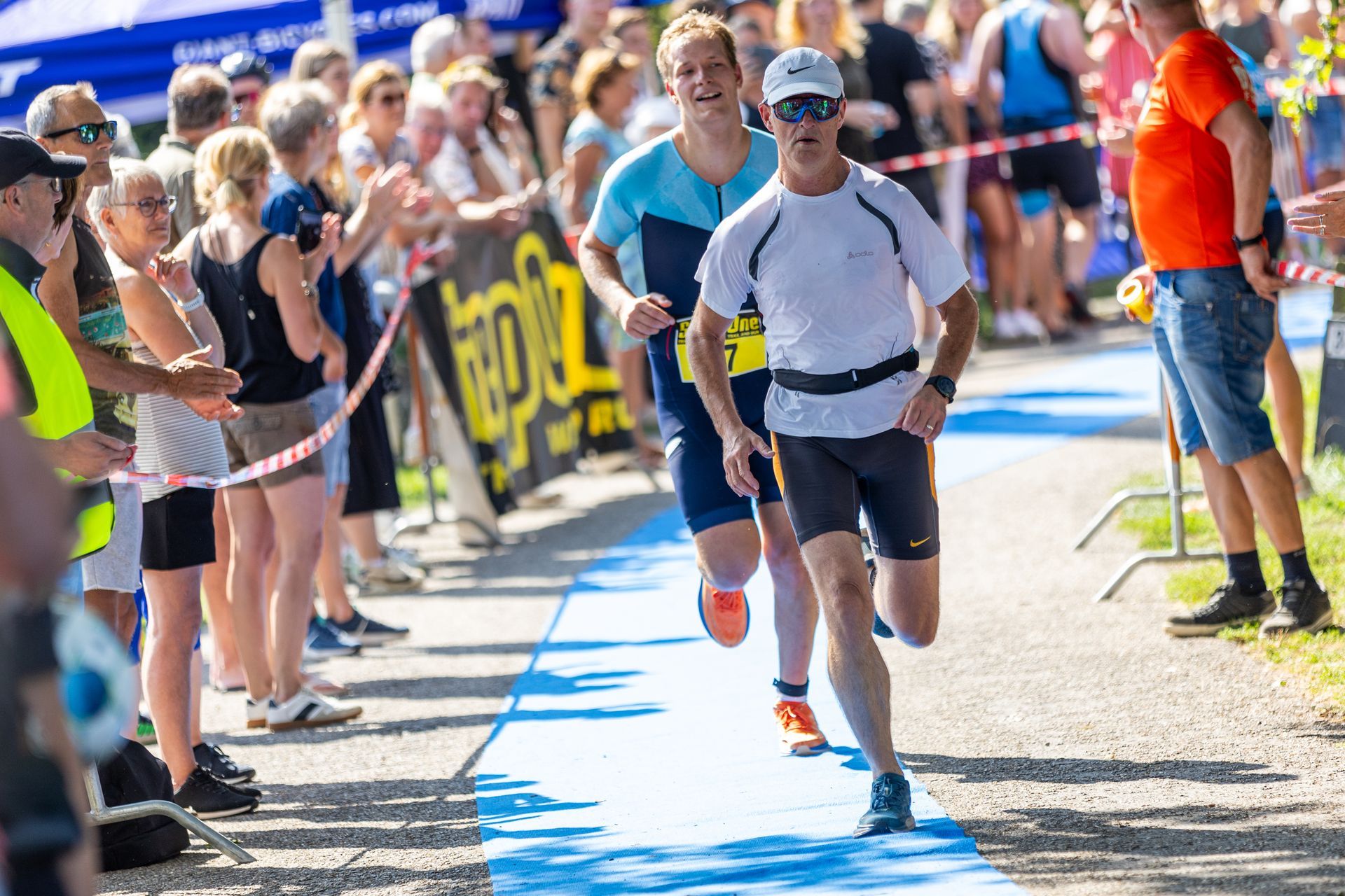 Twee mannen rennen een marathon voor een publiek.