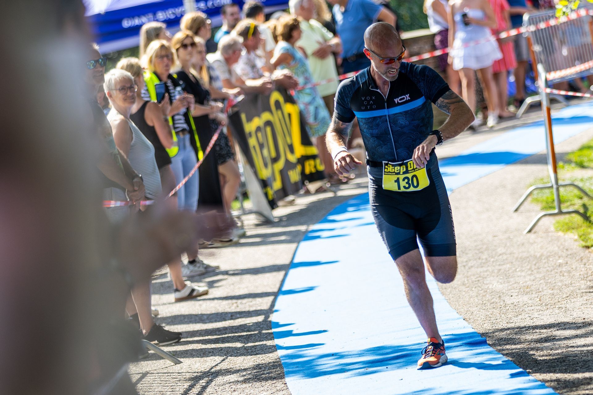 Een man rent een marathon op een blauwe loper.