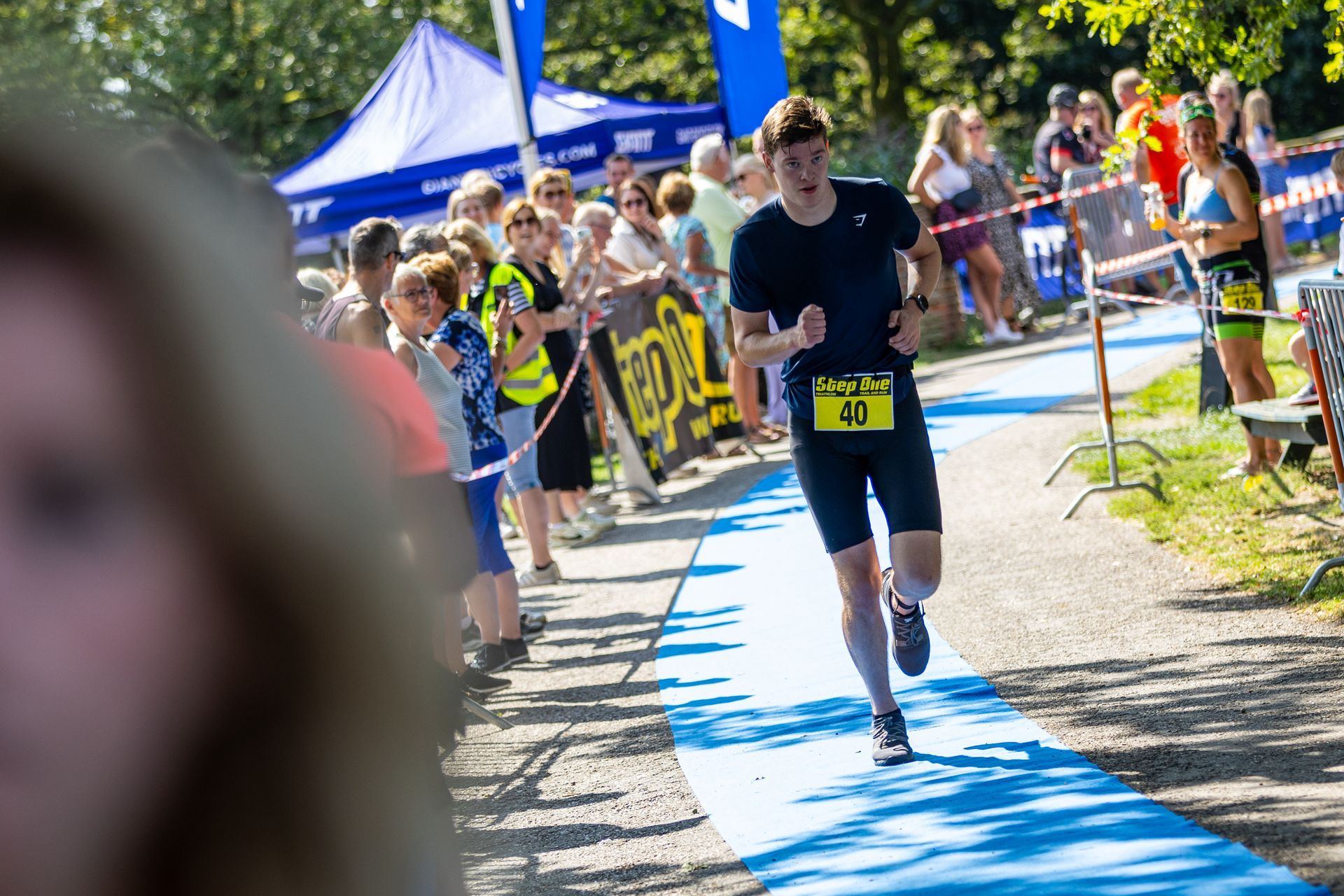 Een man rent een marathon op een blauwe loper.