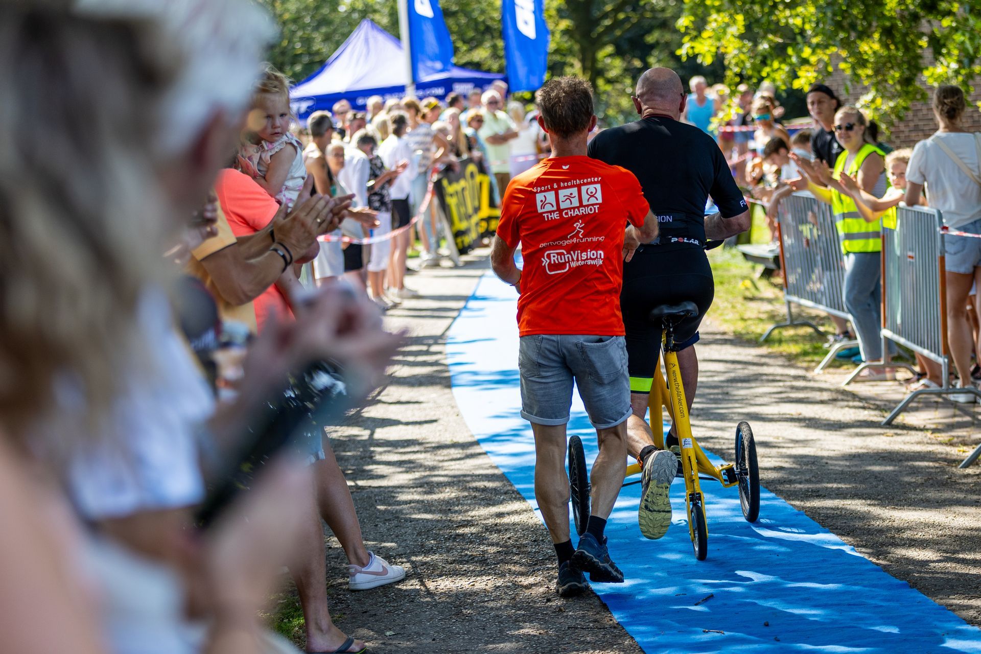 Een man duwt een andere man in een rolstoel over een pad.