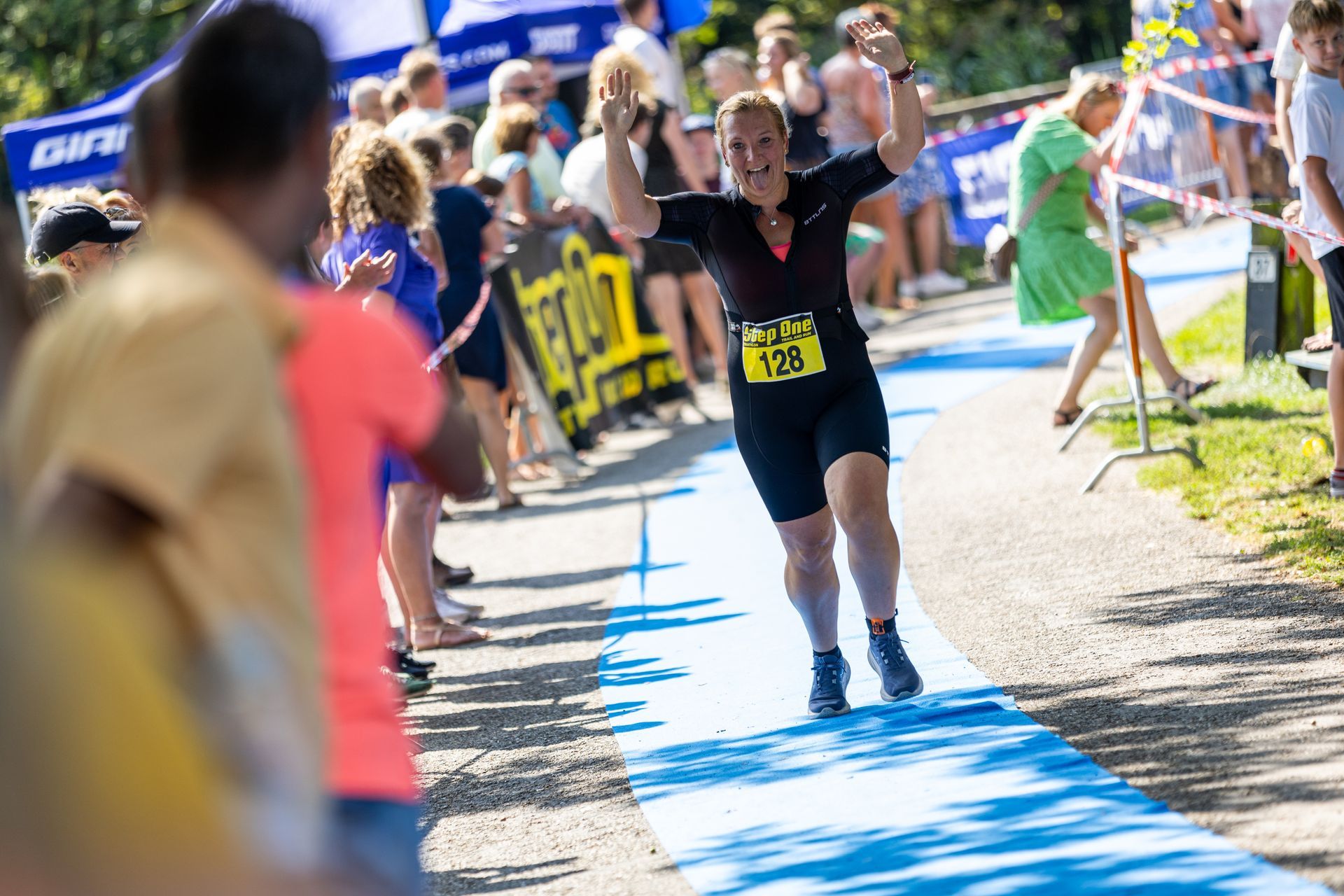 Een vrouw rent een marathon op een blauwe loper.