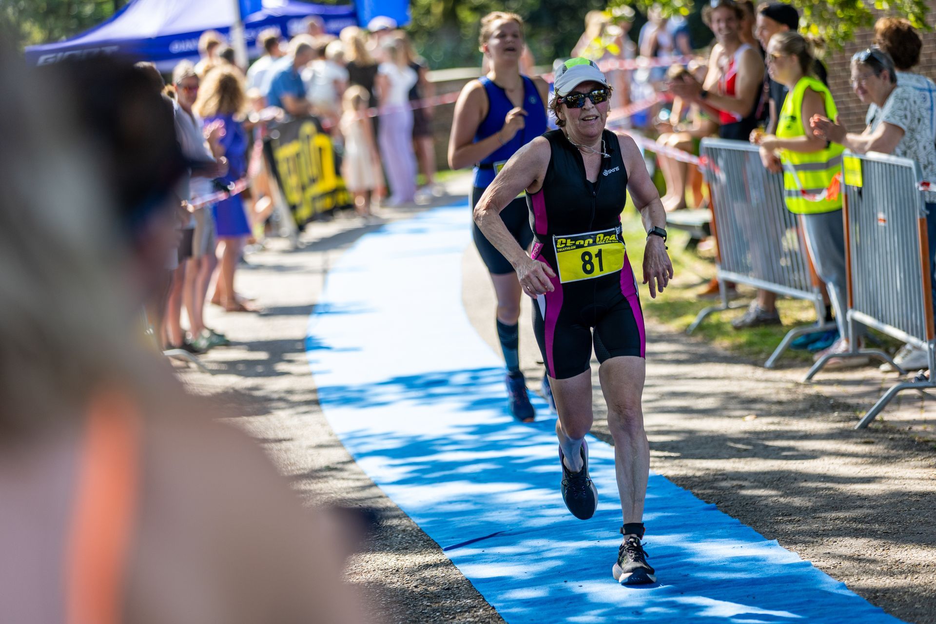 Een vrouw rent een triatlon voor een publiek.