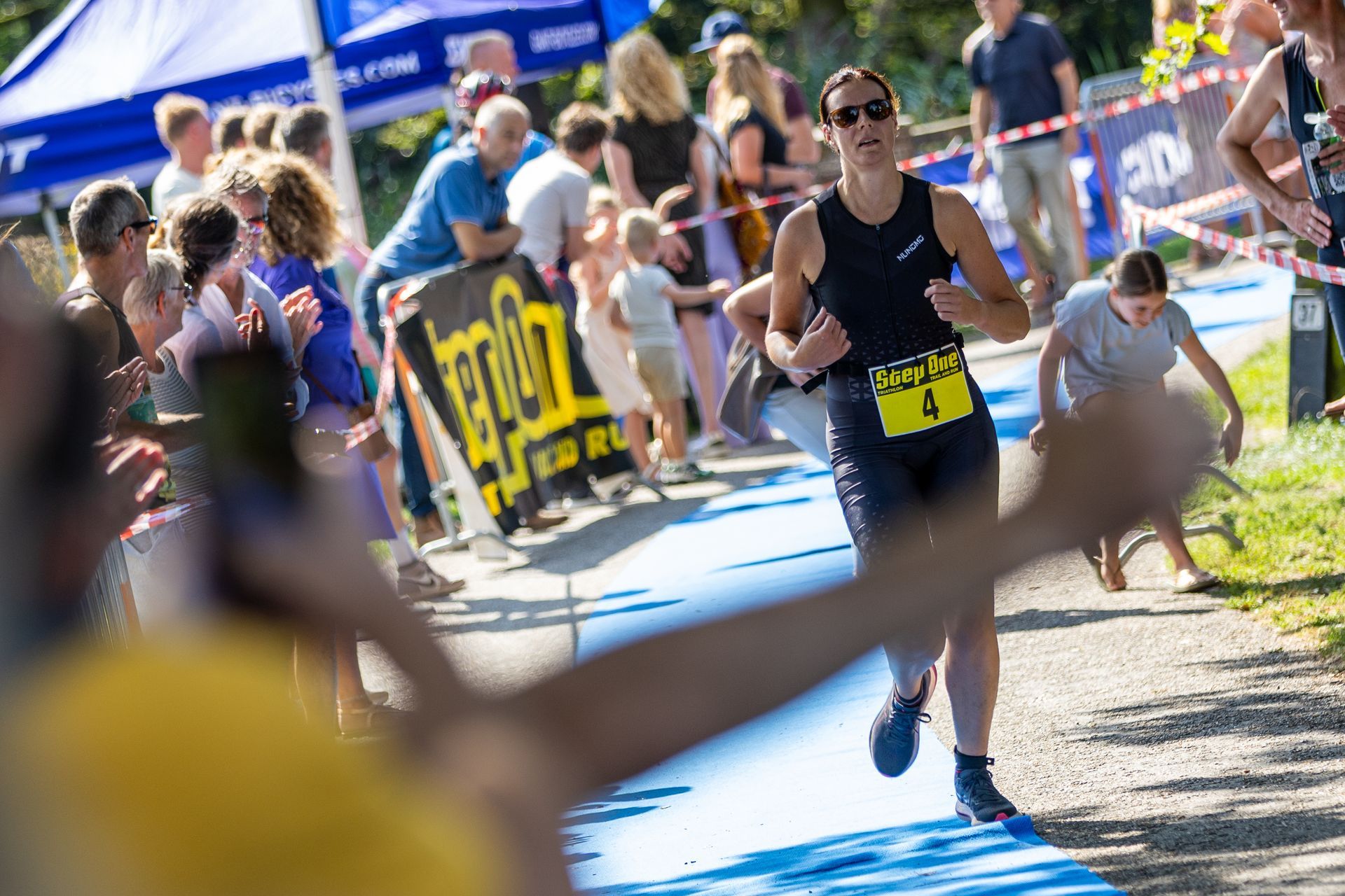 Een man rent een marathon voor een grote groep mensen.