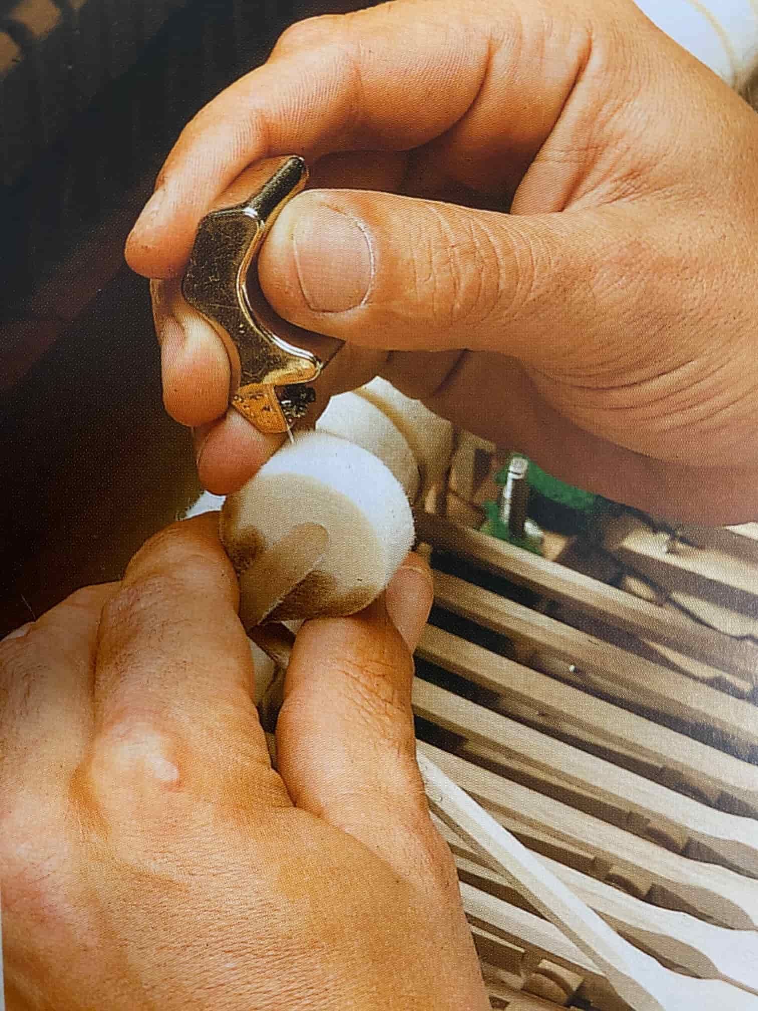 A Person Is Holding A Piece Of Metal In Their Hand — Doug Simpson Piano Tuning In Manunda, QLD