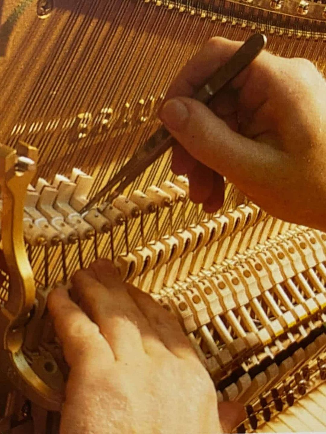 A Person Is Working On A Piano With A Pair Of Scissors — Doug Simpson Piano Tuning In Manunda, QLD