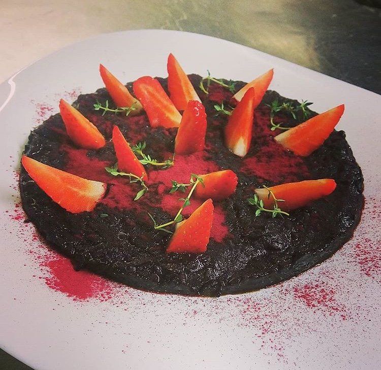 Un piatto bianco condito con salsa nera e fette d'arancia