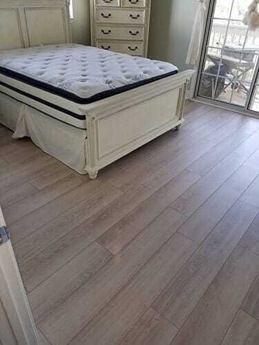 Bedroom with laminated wooden floor - flooring contractors in Jacksonville, FL