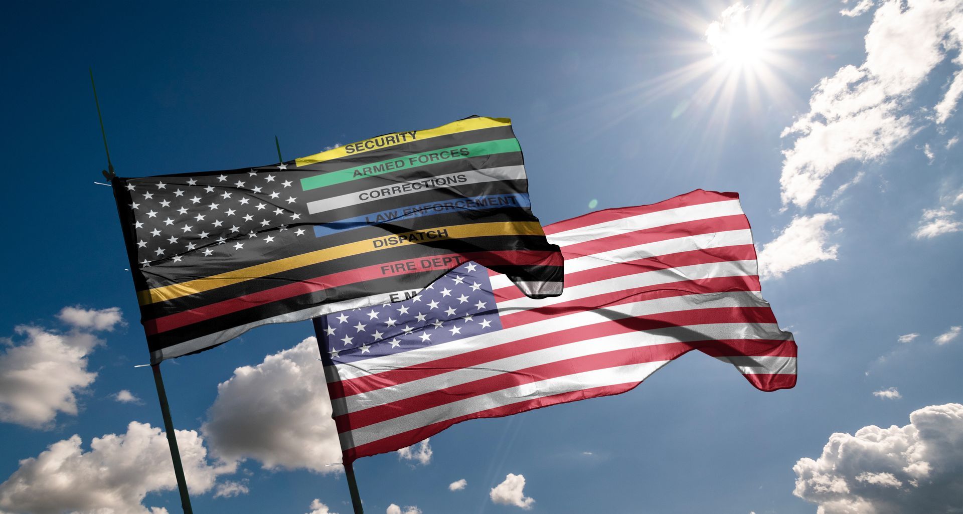 Two American flags waving against a bright sun and blue sky with clouds; one flag is a modified thin line flag.
