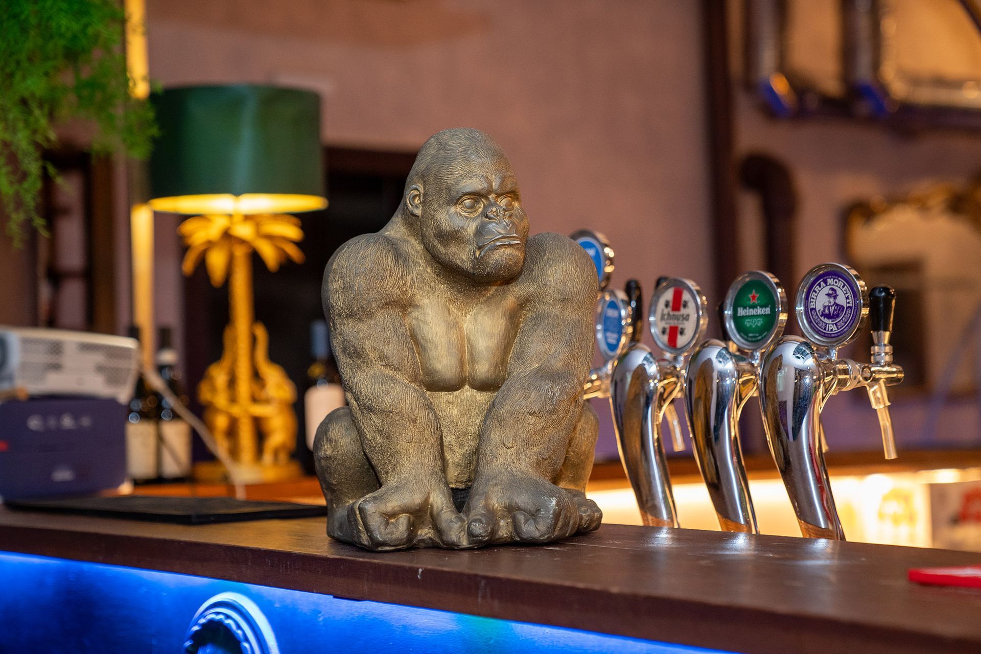 Una statua di un gorilla seduto in cima a un bar.