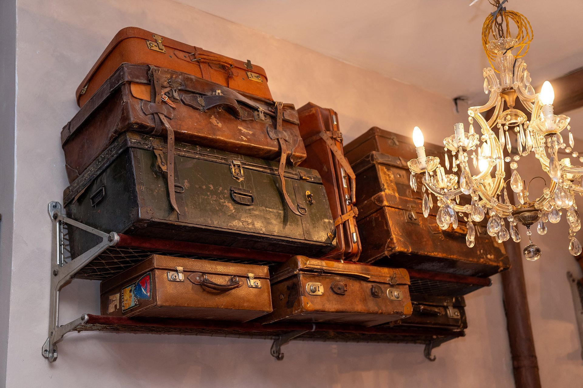 Un mucchio di valigie sono accatastate una sopra l'altra su uno scaffale.