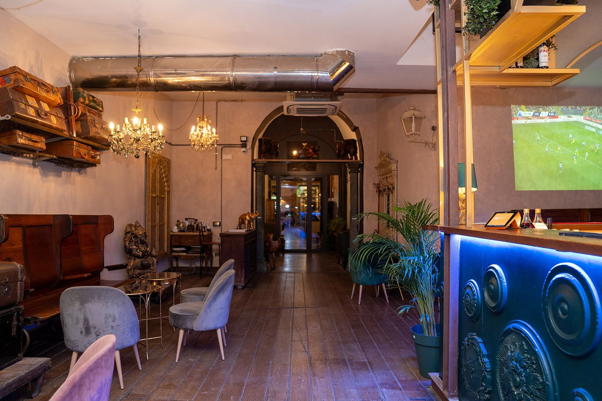 Una grande stanza con molti mobili e una televisione alla parete.