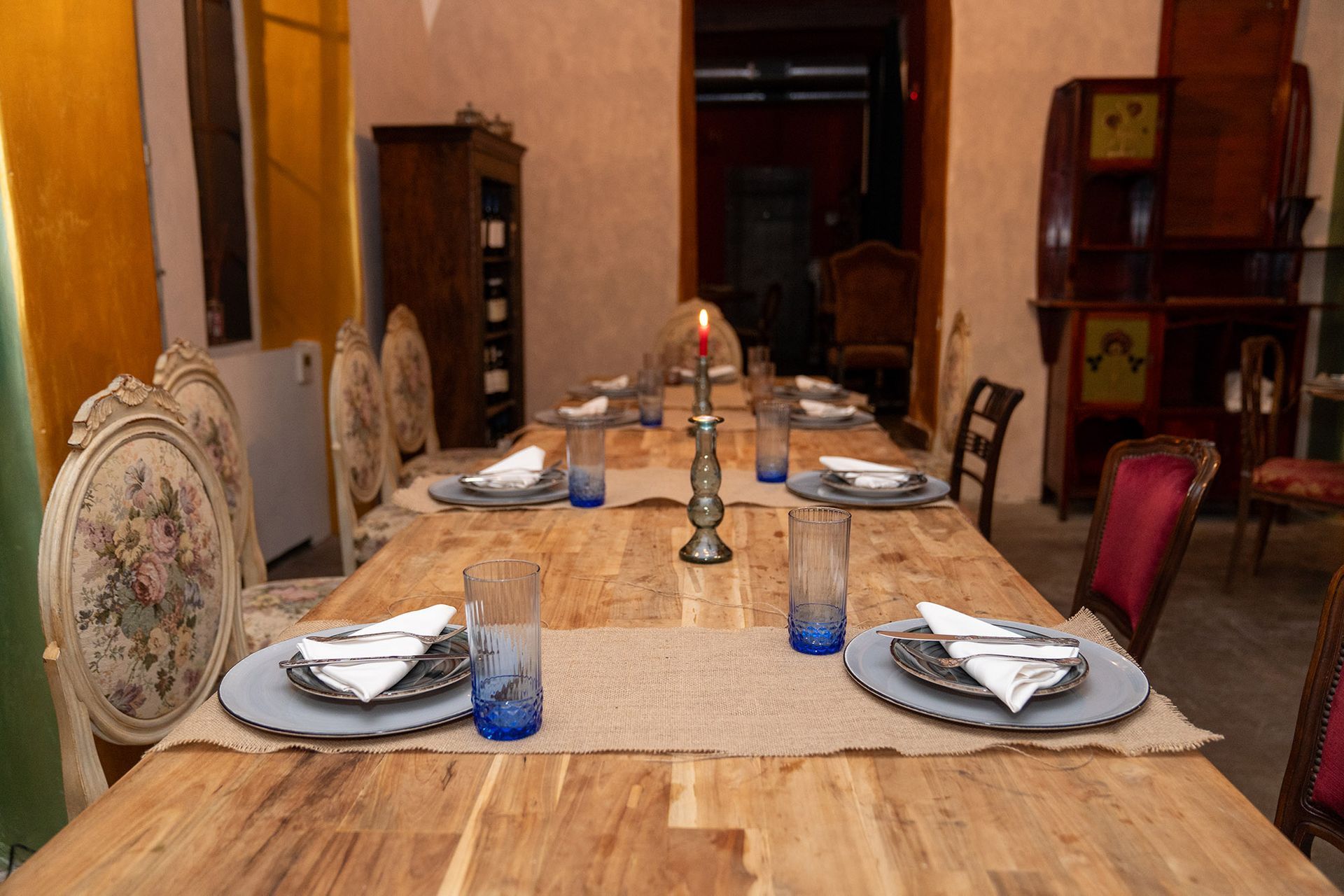 Un lungo tavolo di legno con piatti e bicchieri sopra