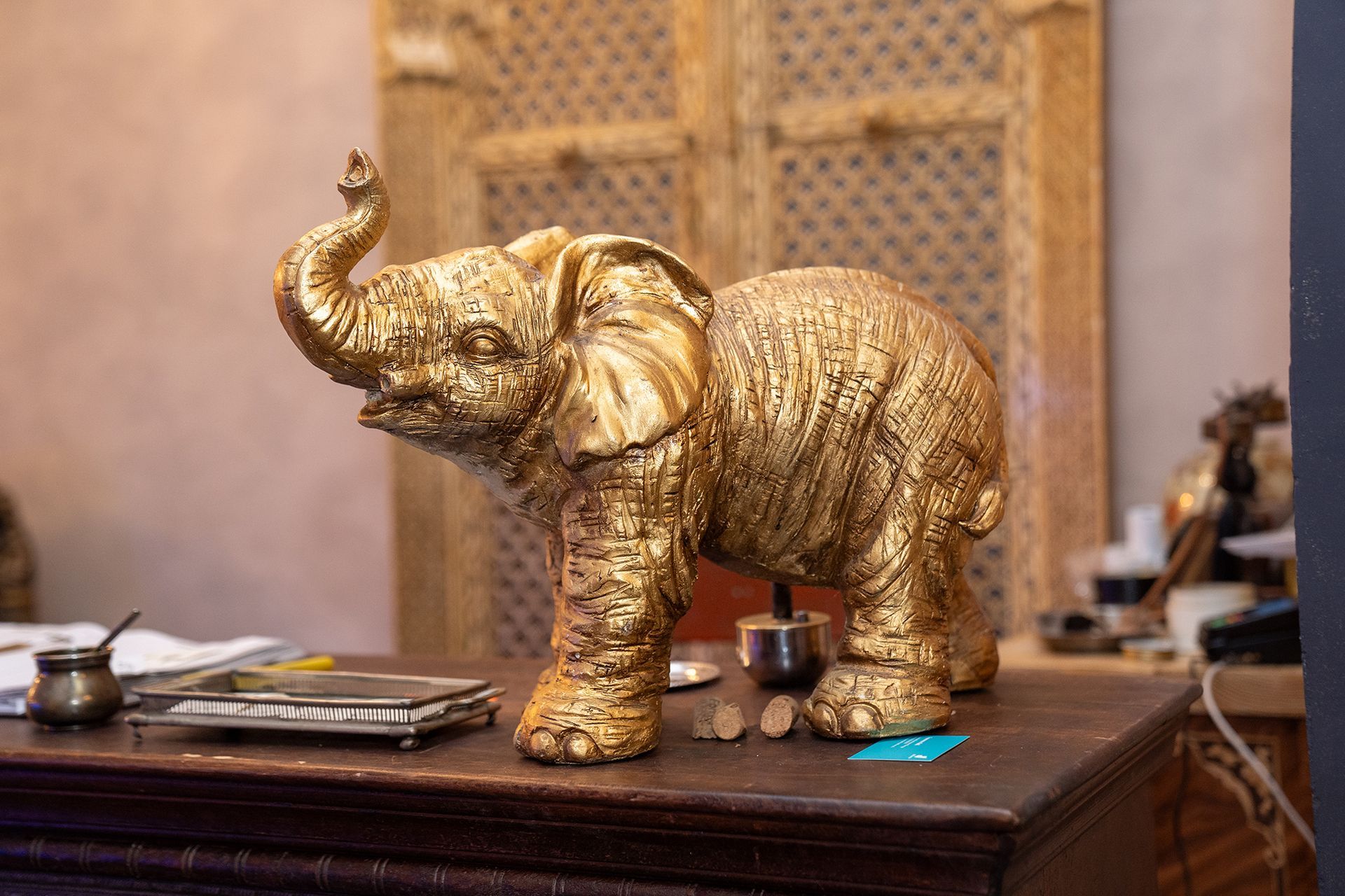 Una statua di elefante d'oro è seduta su un tavolo di legno.
