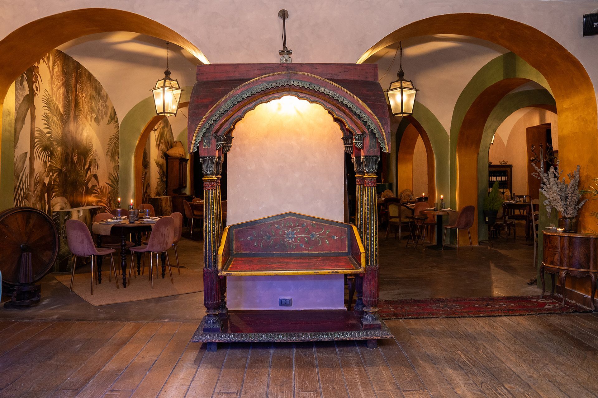 Una stanza con archi e una panca al centro