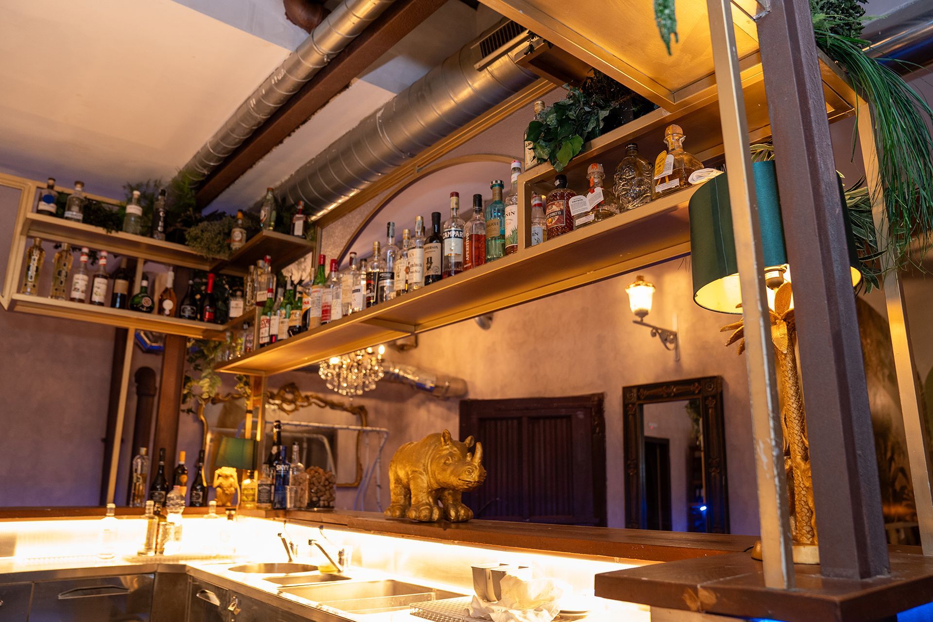 Un bar con bottiglie sugli scaffali e una statua di rinoceronte sul bancone