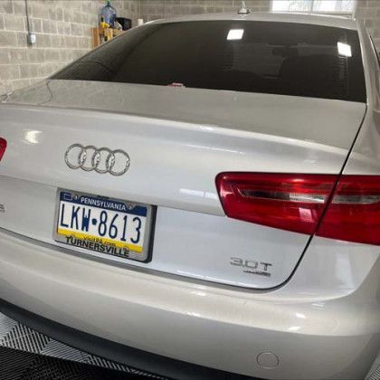 A white audi with a pennsylvania license plate is parked in a garage.