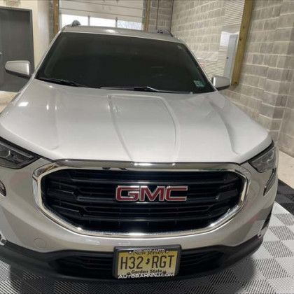 A white gmc truck is parked in a garage.