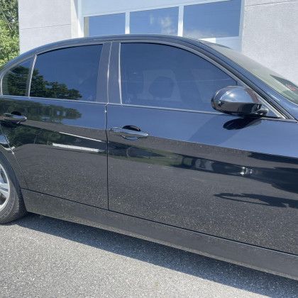 A black car is parked in front of a building
