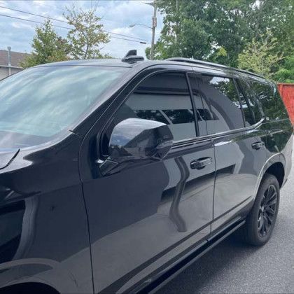 A black suv is parked on the side of the road.