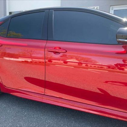 A red car is parked on the side of the road.
