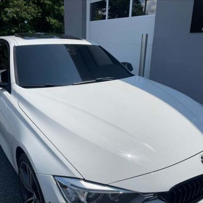 A white car is parked in front of a garage door.