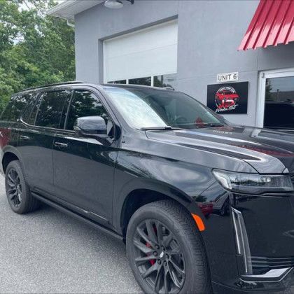 A black suv is parked in front of a garage.
