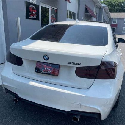 A white bmw is parked in front of a building.