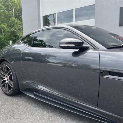A black sports car is parked in front of a building.