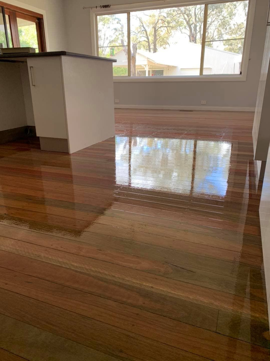 Newly Polished Kitchen Floor with a Shelve and Window In Background — Floor Sanding in Kearneys Spring, QLD