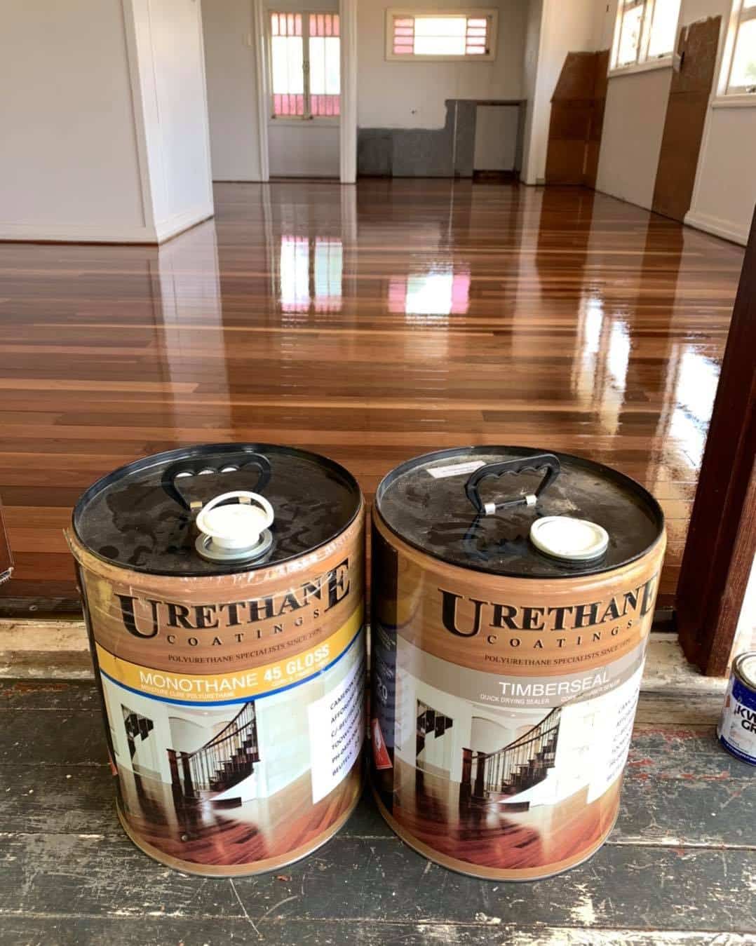 Two Urethane Coatings Cans In Front of Shiny Floor — Floor Sanding in Kearneys Spring, QLD