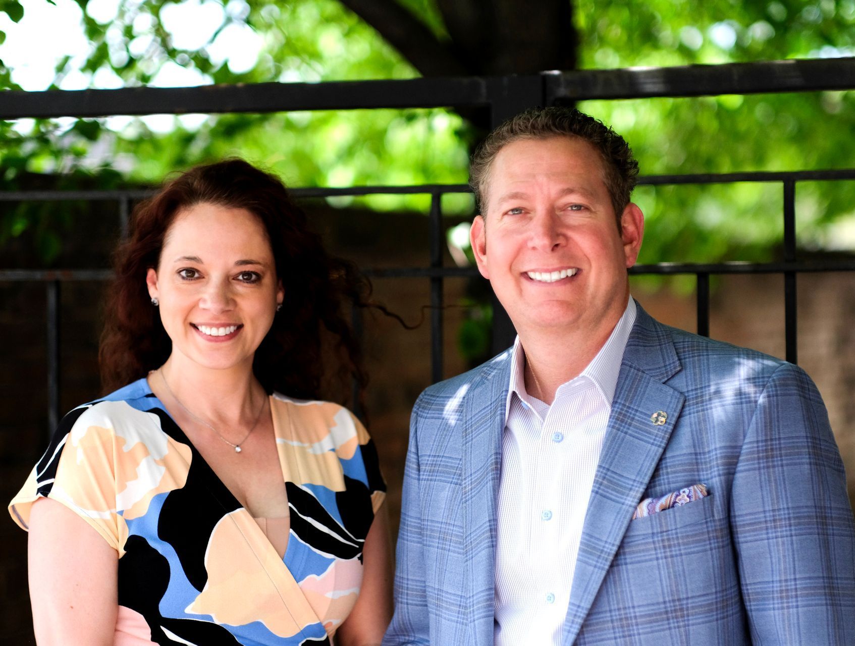 A man and a woman are standing next to each other and smiling.
